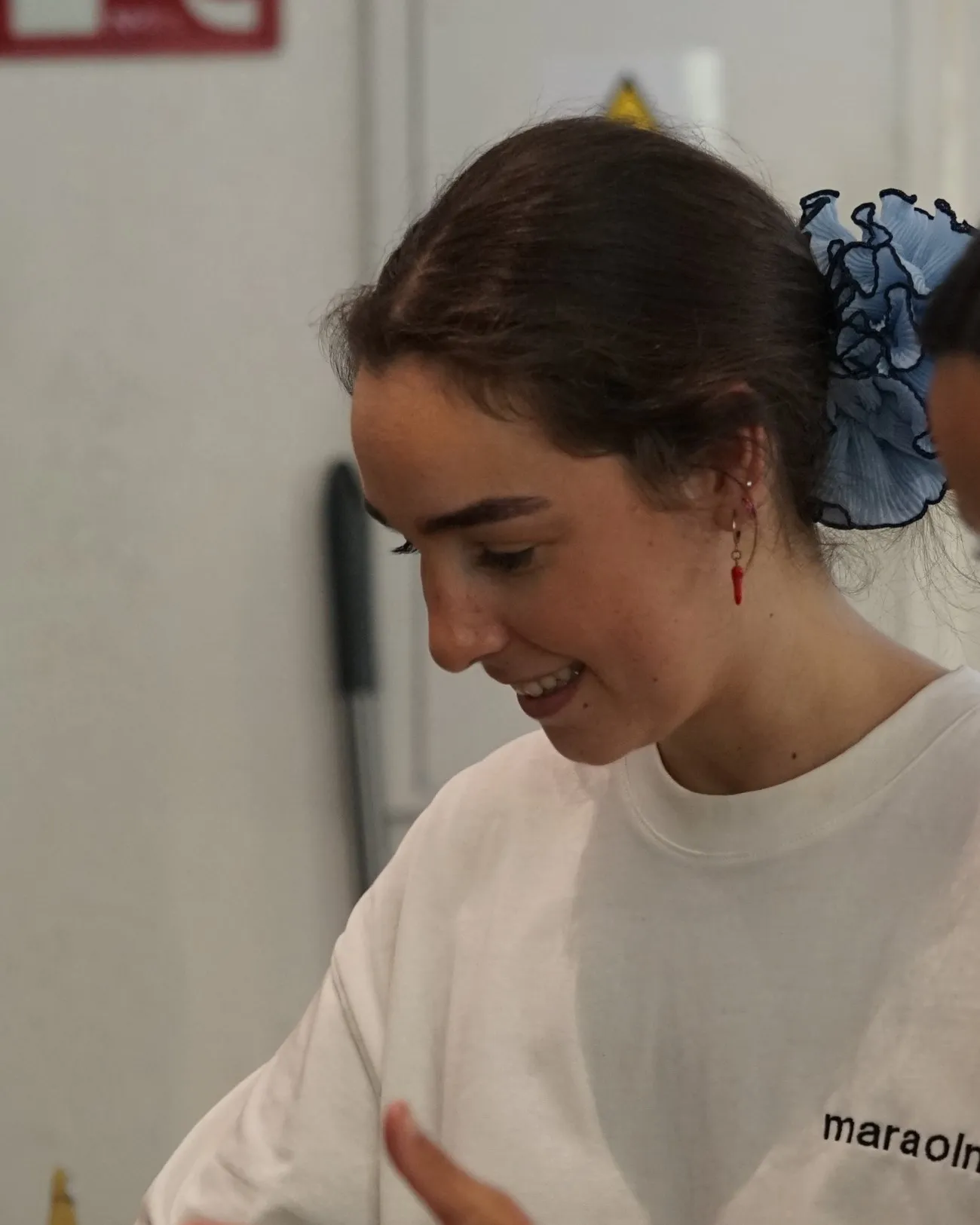 Mara Olmos de perfil, sonriendo mientras cocina